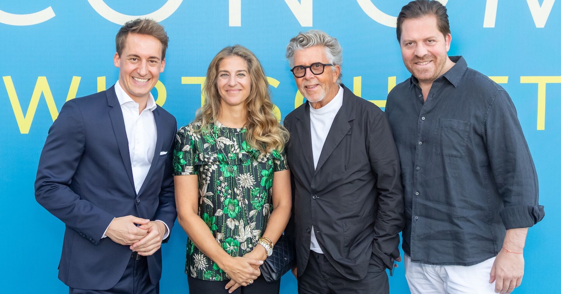 Vier Vernissage-Gäste vor einer blauen Wand im VIP Terminal Wien