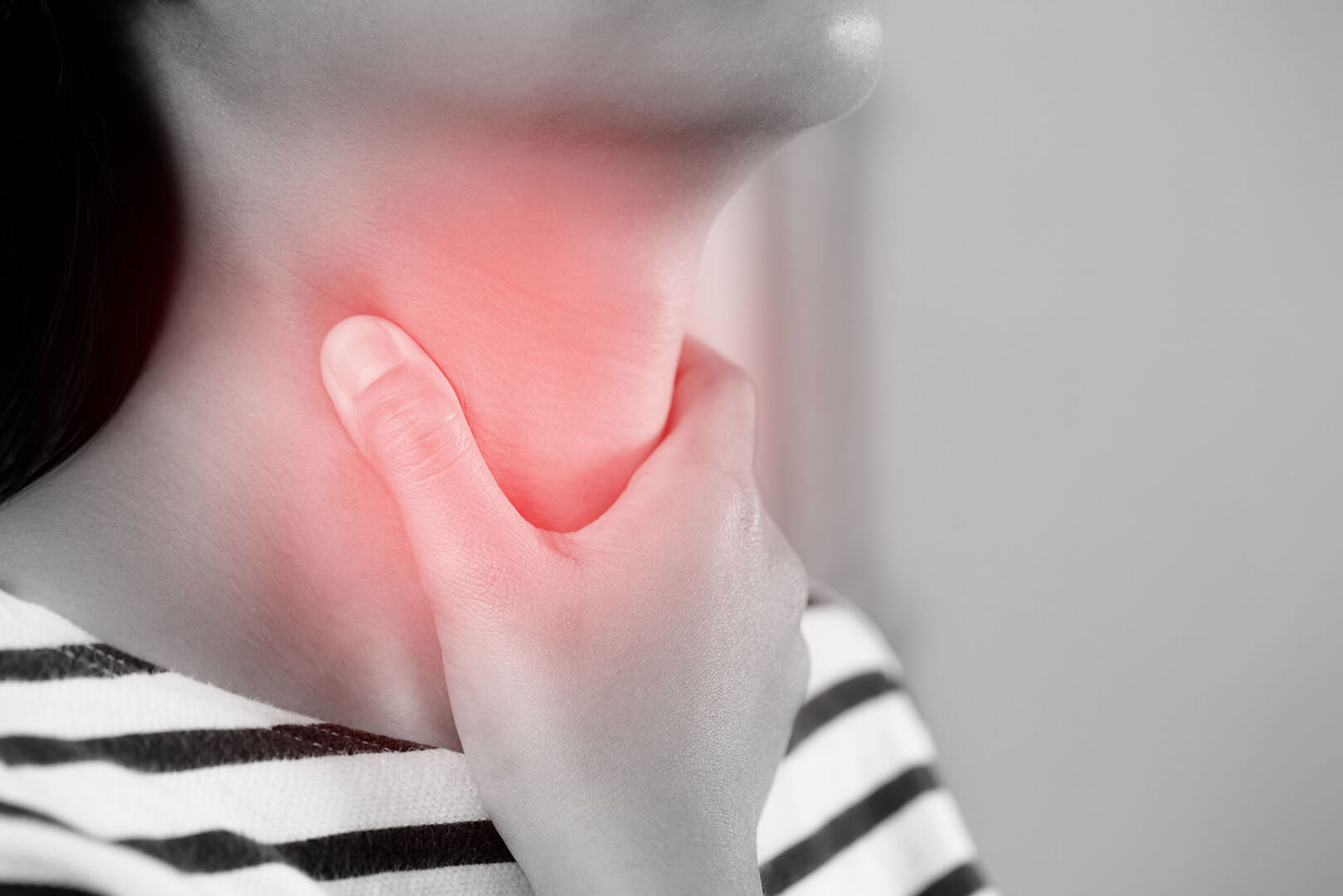 Frau greift sich an Hals | Credit: iStock.com/Rattankun Thongbun