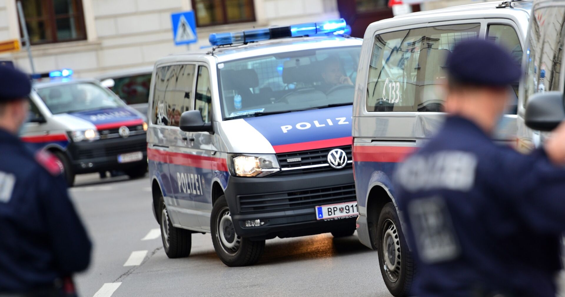 Polizisten und Polizeiautos an einem Einsatzort.