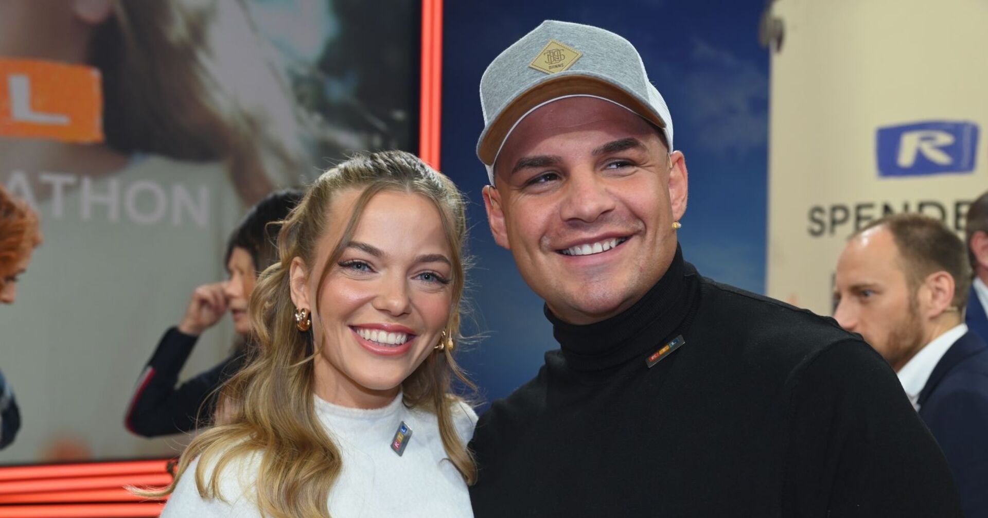 Laura Maria Rypa und Pietro Lombardi lächeln Arm in Arm bei einem öffentlichen Event in die Kamera, beide wirken glücklich.