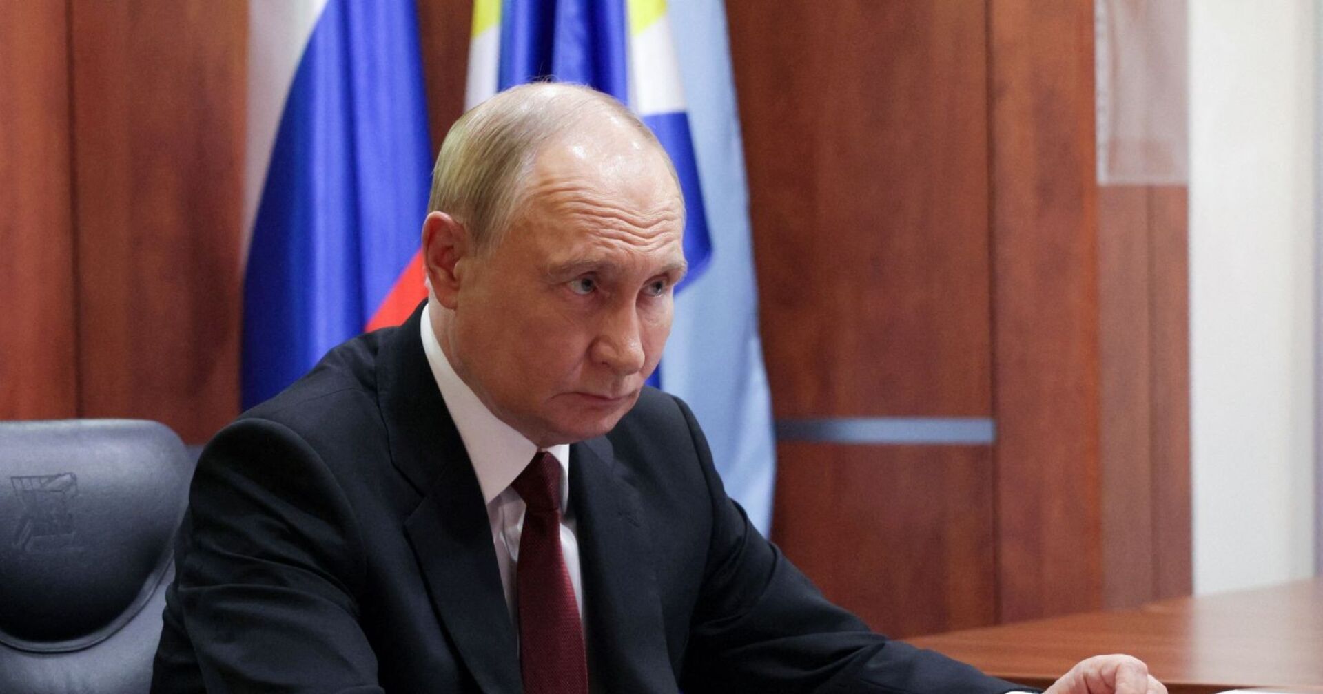 Russlands Präsident Wladimir Putin bei einer offiziellen Ansprache in Moskau, vor russischer Flagge und im Anzug