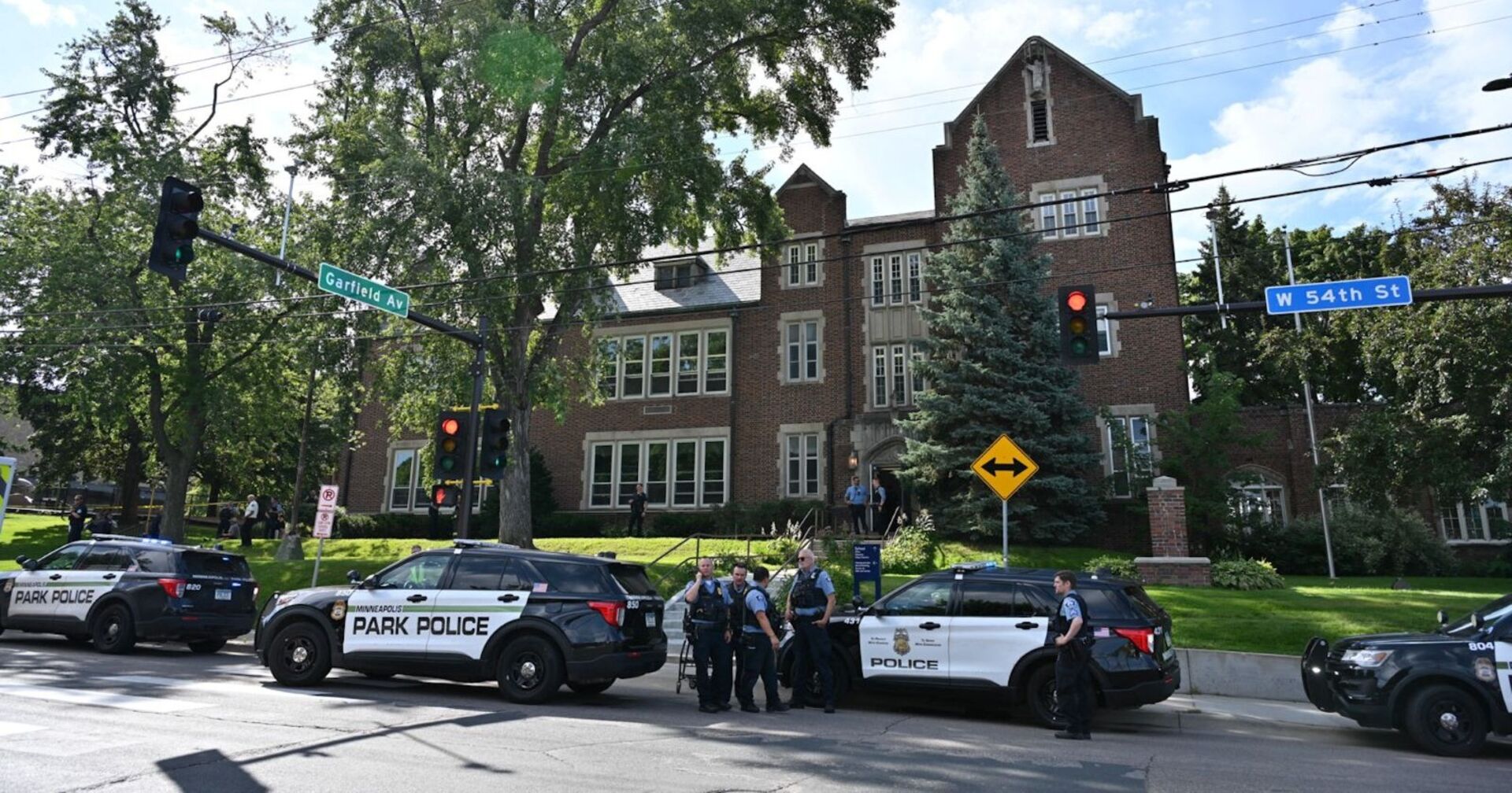 Mehrere Polizeiautos und Beamte stehen vor der Annunciation Catholic School in Minneapolis an der Kreuzung Garfield Avenue und West 54th Street nach einer Schießerei während einer Messe.