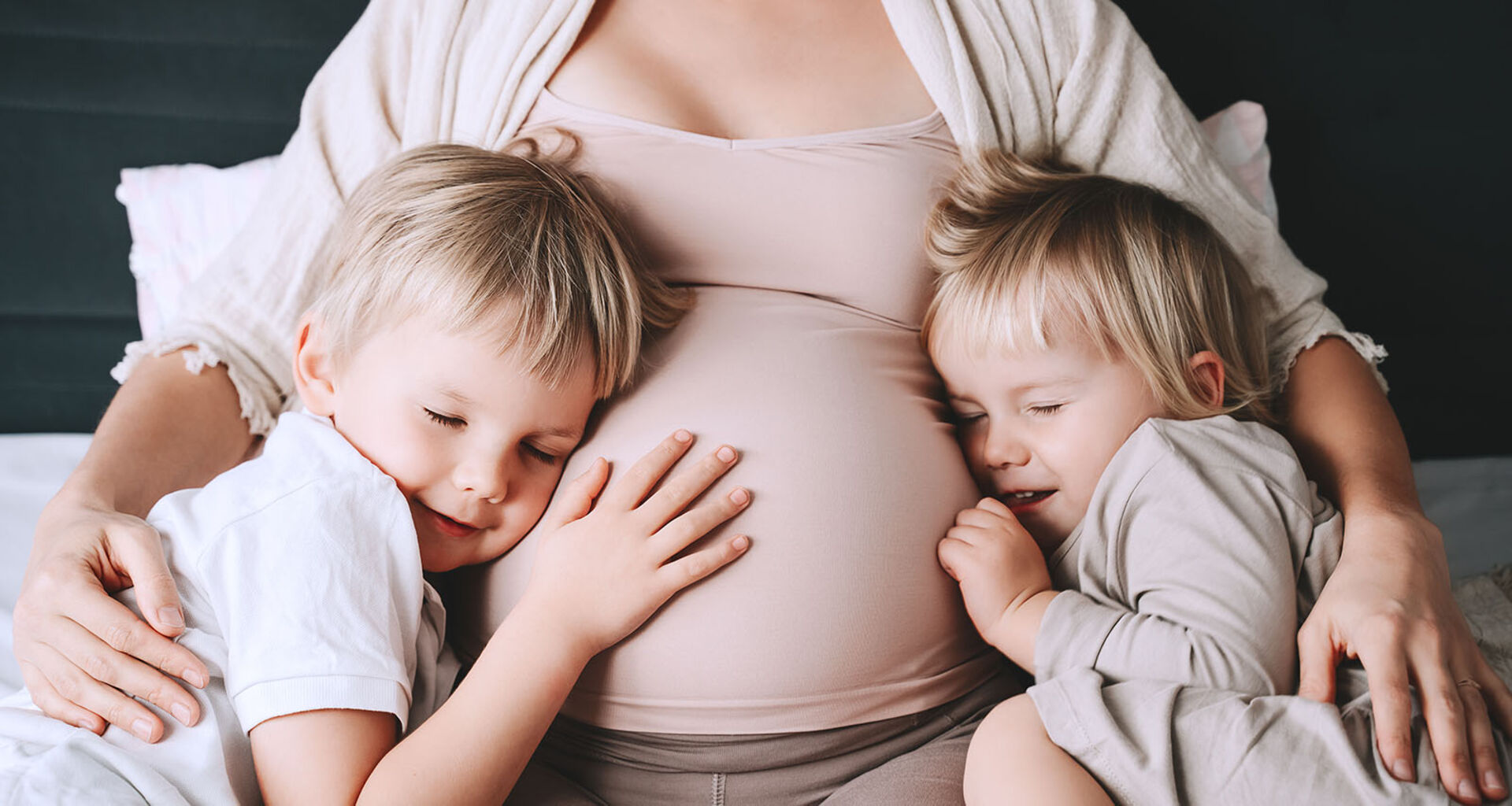 Schwangere Frau mit zwei Kindern | Credit: iStock.com/NataliaDeriabina