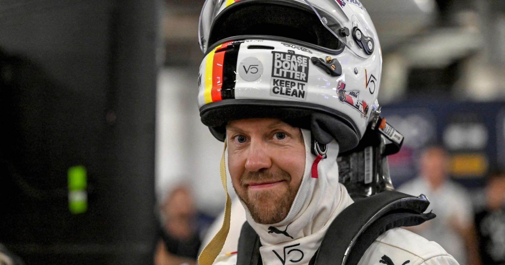Sebastian Vettel trägt Rennanzug und Helm, lächelt in die Kamera; der vierfache Formel-1-Weltmeister hält sich eine Rückkehr in neuer Rolle offen.