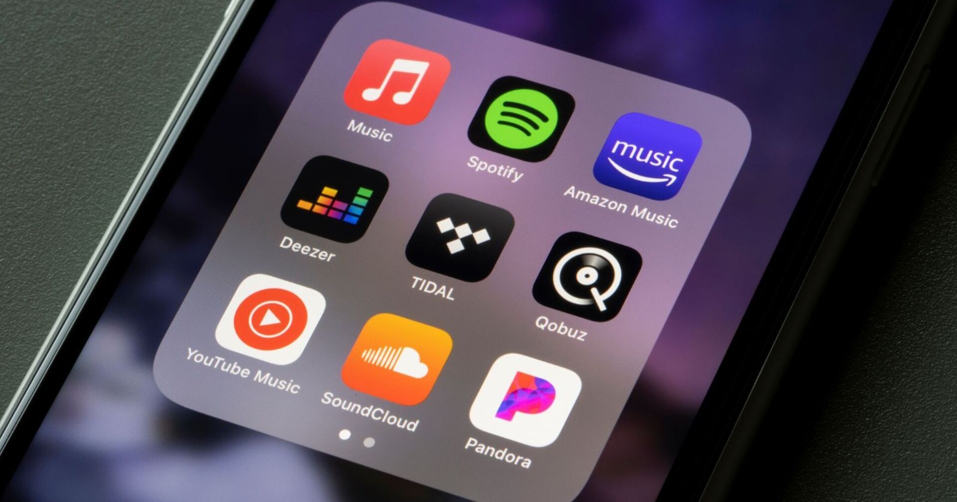 Smartphone-Bildschirm mit App-Icons von Musikstreaming-Diensten: Apple Music, Spotify, Amazon Music, Deezer, Tidal, Qobuz, YouTube Music, SoundCloud und Pandora.