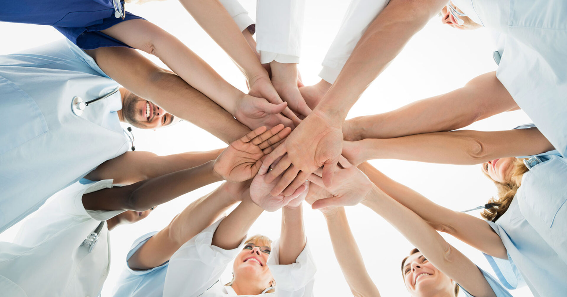 Gruppe von Menschen im Kreis, die sich an den Händen halten | Credit: iStock.com/Andrey Popov