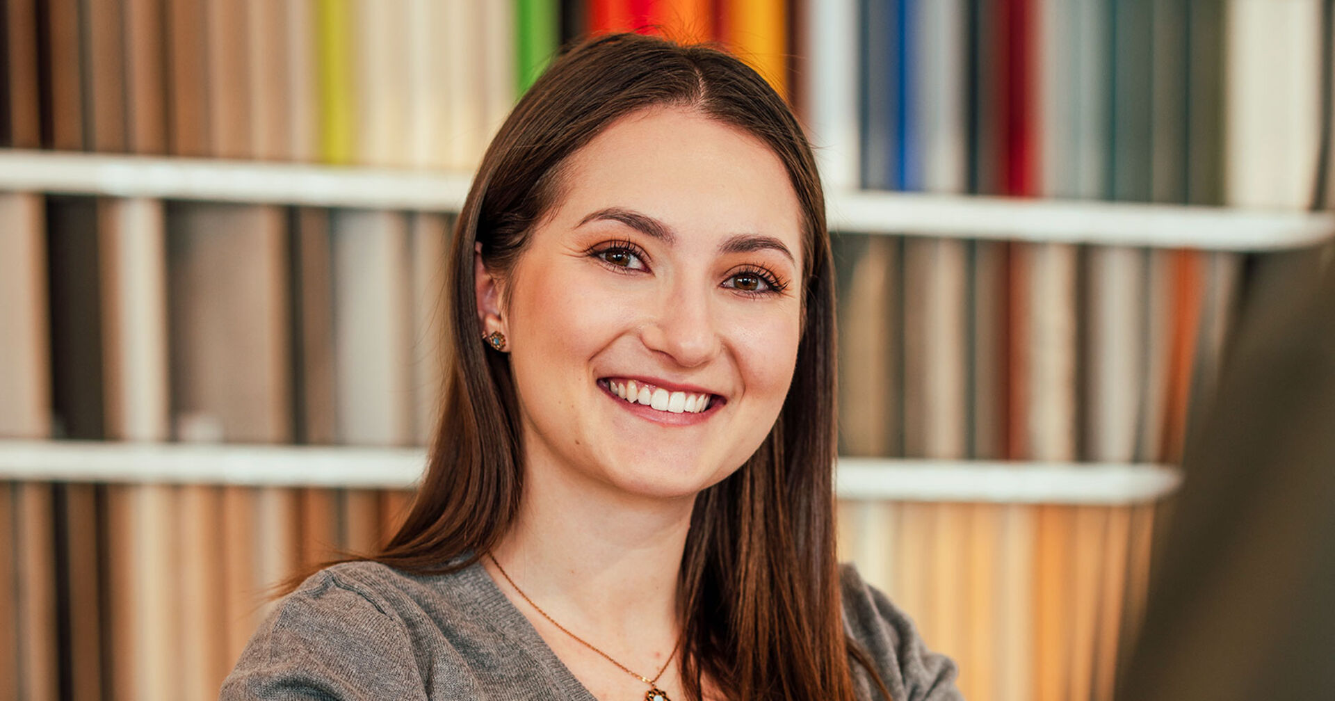 Junge lächelnde Frau im Büro | Credit: iStock.com/Chanakan Phinakan