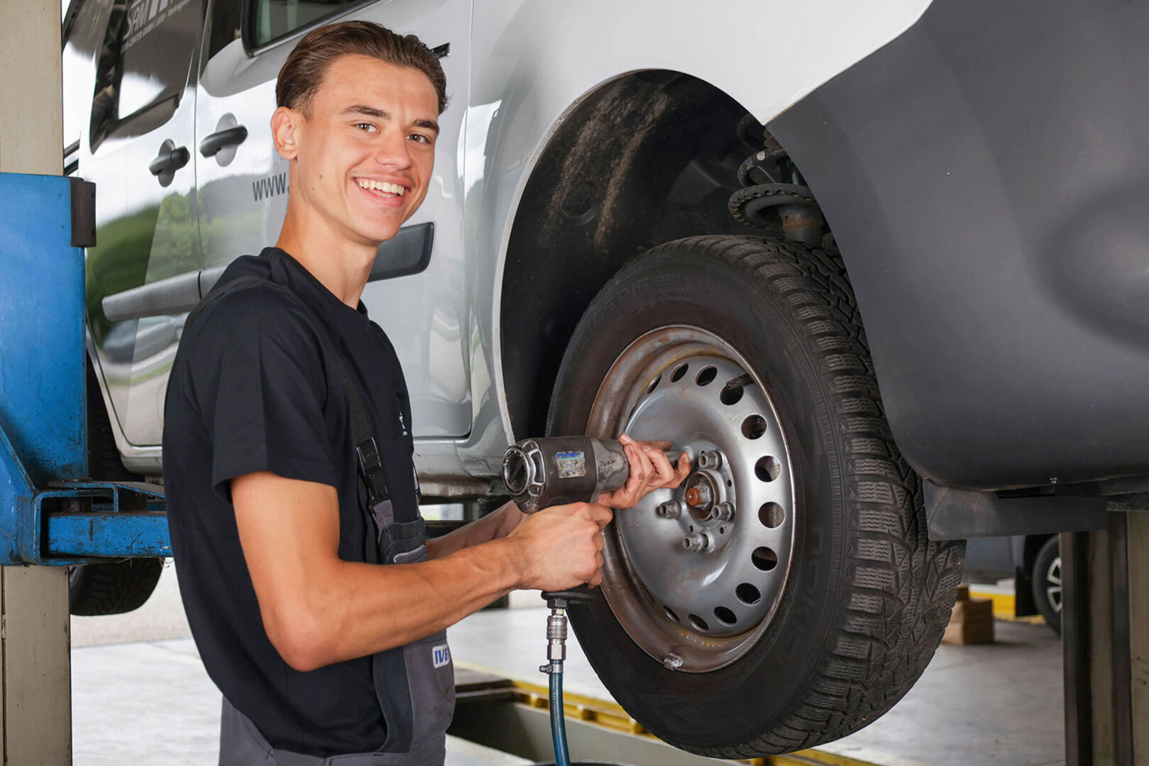 Junger Mann montiert in einer Werkstatt einen Reifen | Credit: Samhaber LKW-Center
