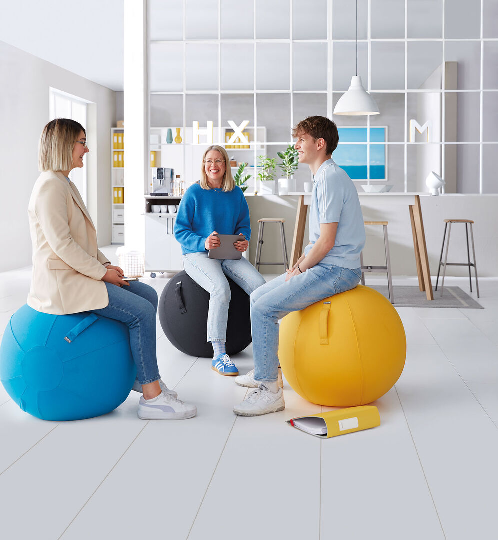 Gruppe von Mitarbeitenden beim gemeinsamen Entspannen auf Sitzbällen | Credit: Adobe Stock