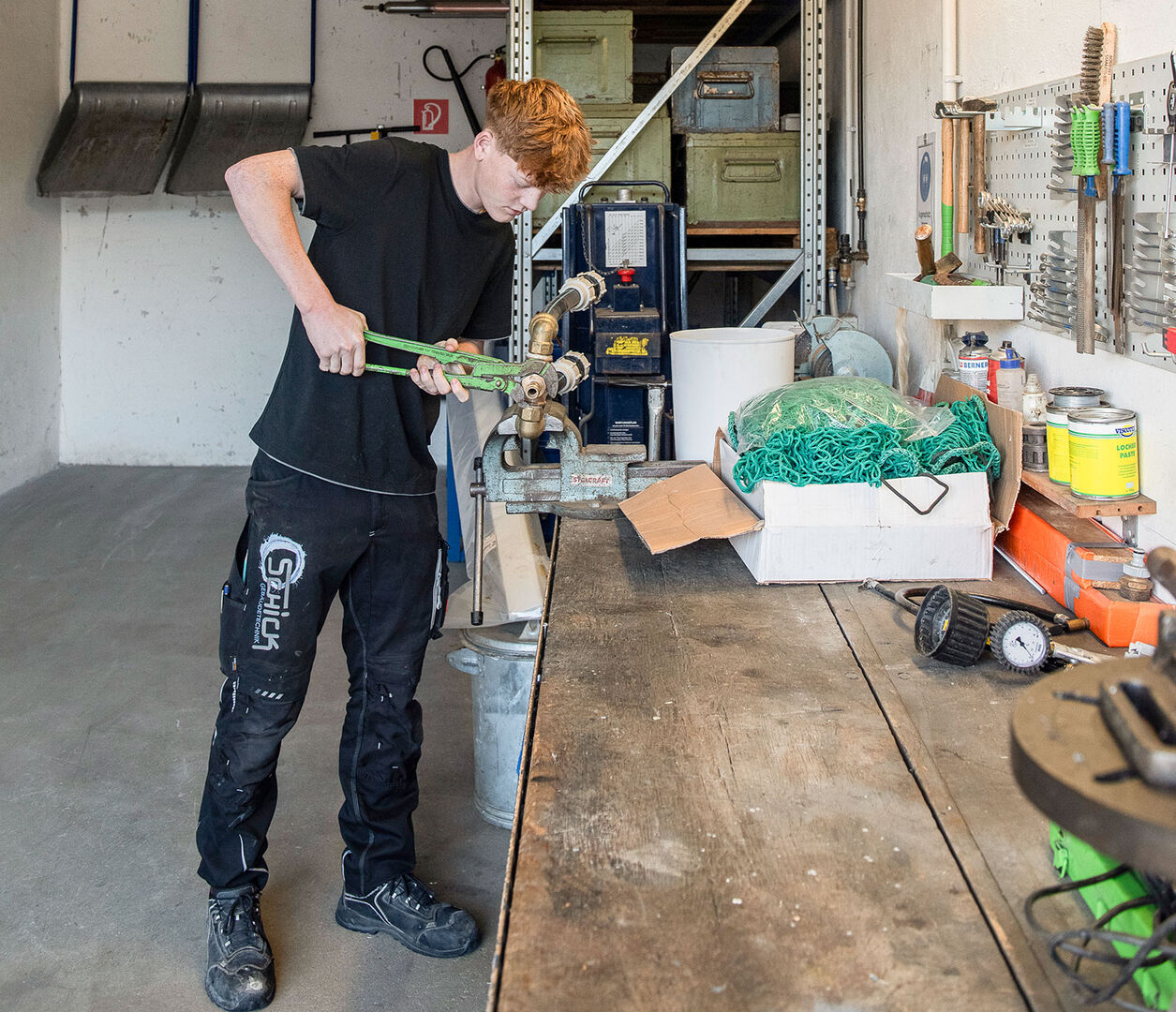 Junger Installateur bei der Reparatur | Credit: Schick Gebäudetechnik