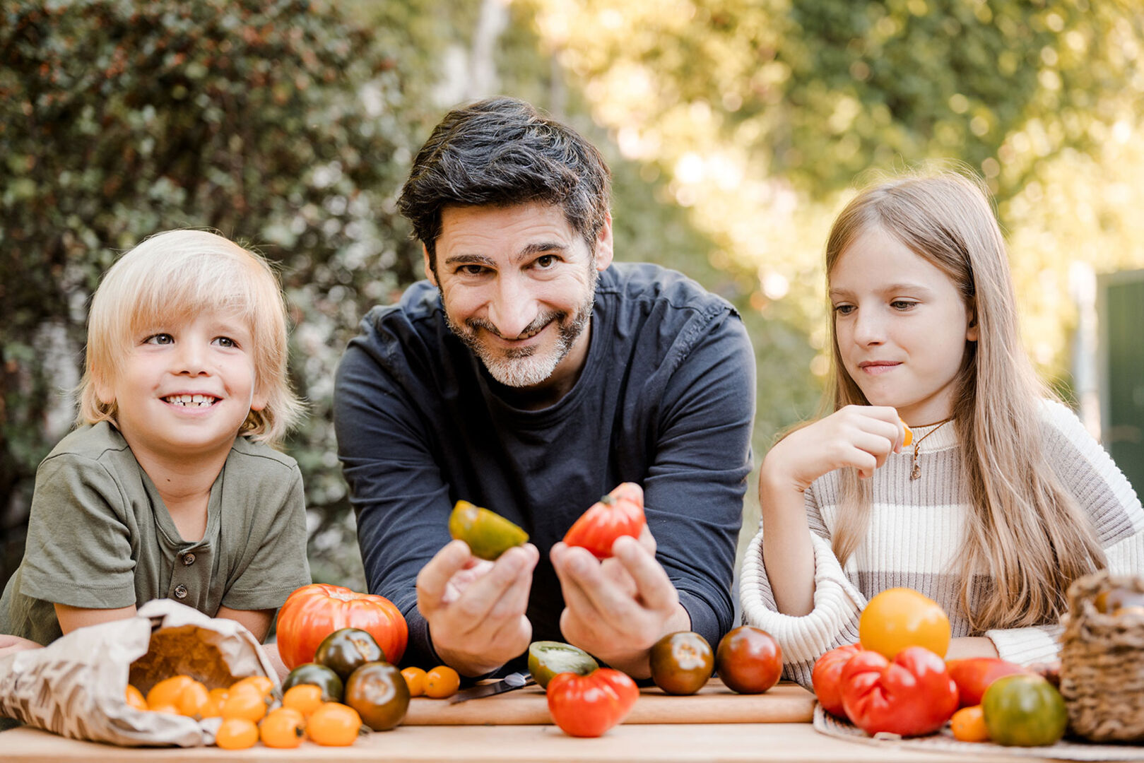 Mann gemeinsam mit einem Jungen und einem Mädchen vor einer Gemüseauswahl | Credit: SPAR/Miriam Mehlman Fotografie