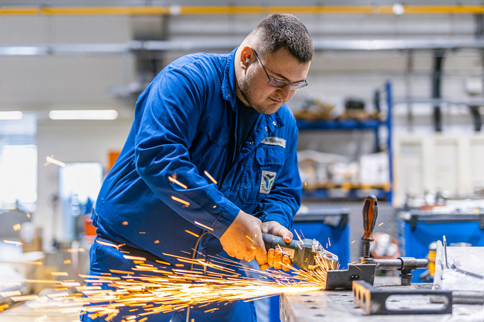 Männlicher Lehrling bei Schweißarbeiten in der Produktionshalle | Credit: TCG UNITECH