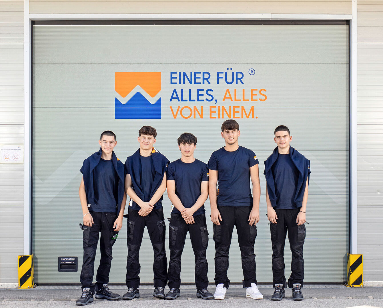 Männliche Lehrlinge vor dem Eingang des Firmengebäudes | Credit: Wohlschlager &amp; Redl