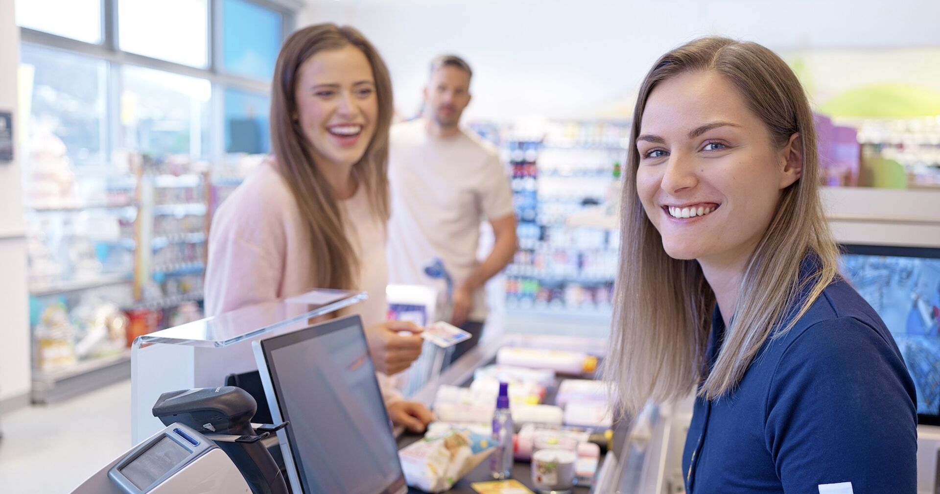 Junge Frau an der Kassa und eine junge Kundin