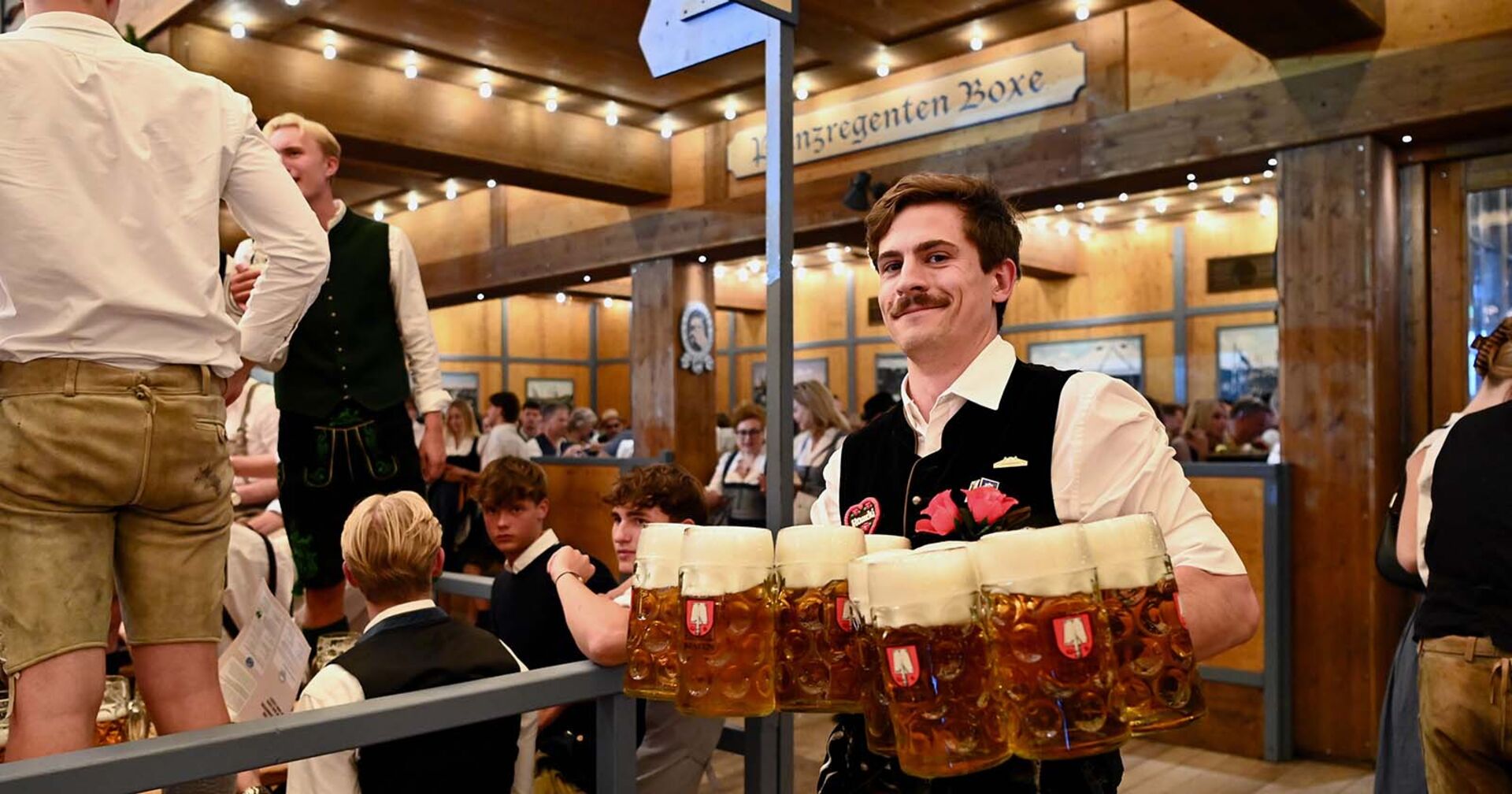 Kellner auf dem Münchner Oktoberfest trägt Maßkrüge