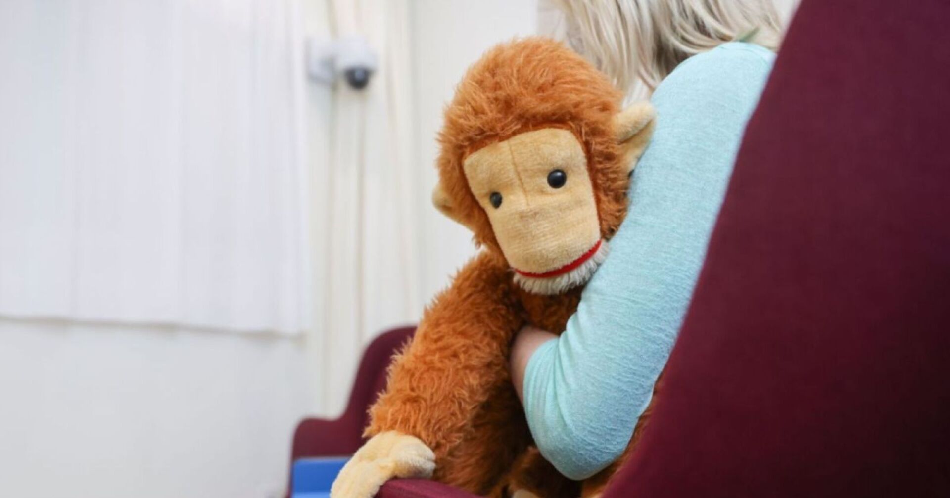 Kind mit Stofftier auf einem Sessel, Symbolbild für Opferschutz und Missbrauchsaufarbeitung.