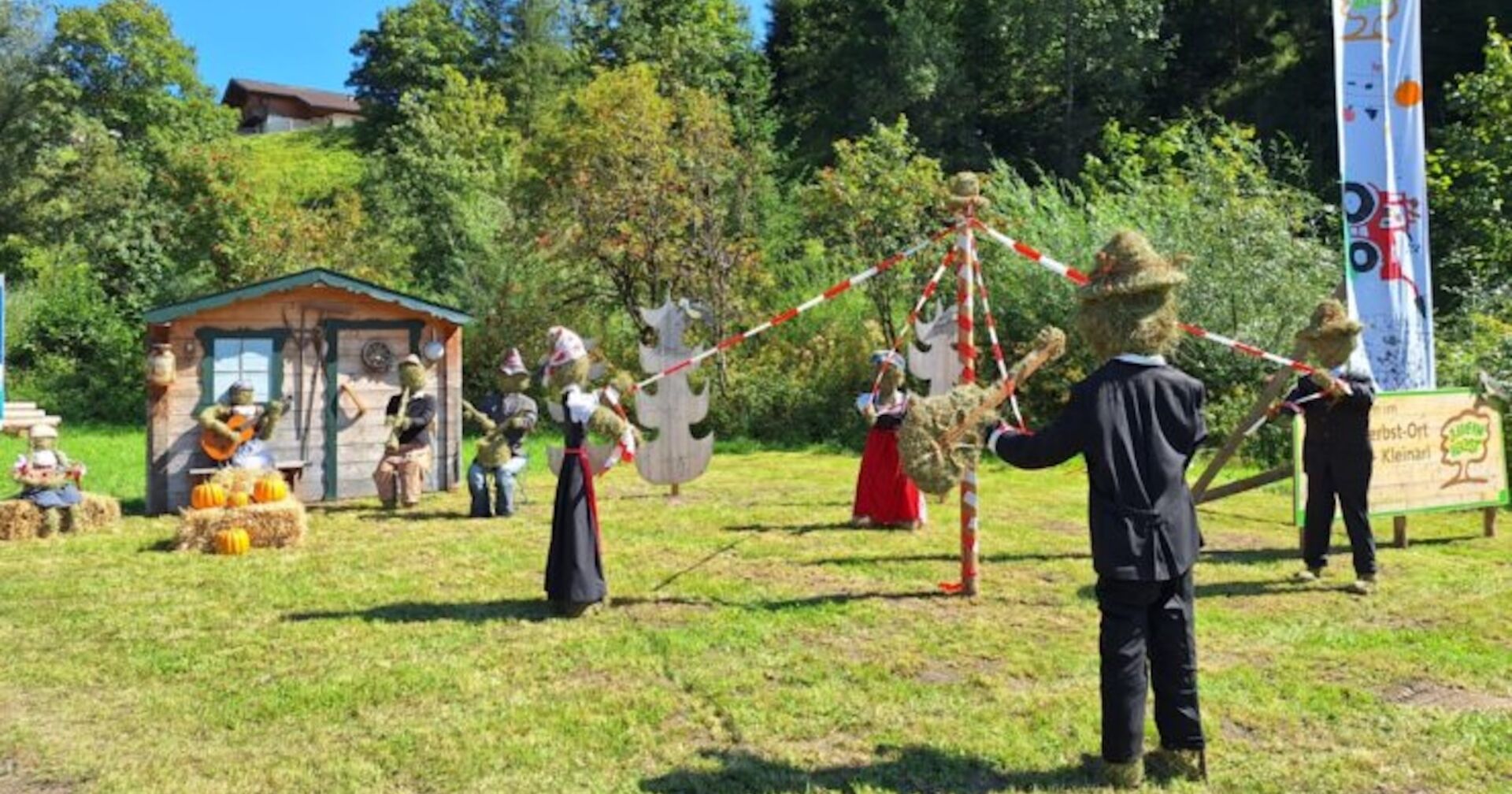 Heupuppen-Kunstwerk vor einer Ortseinfahrt.