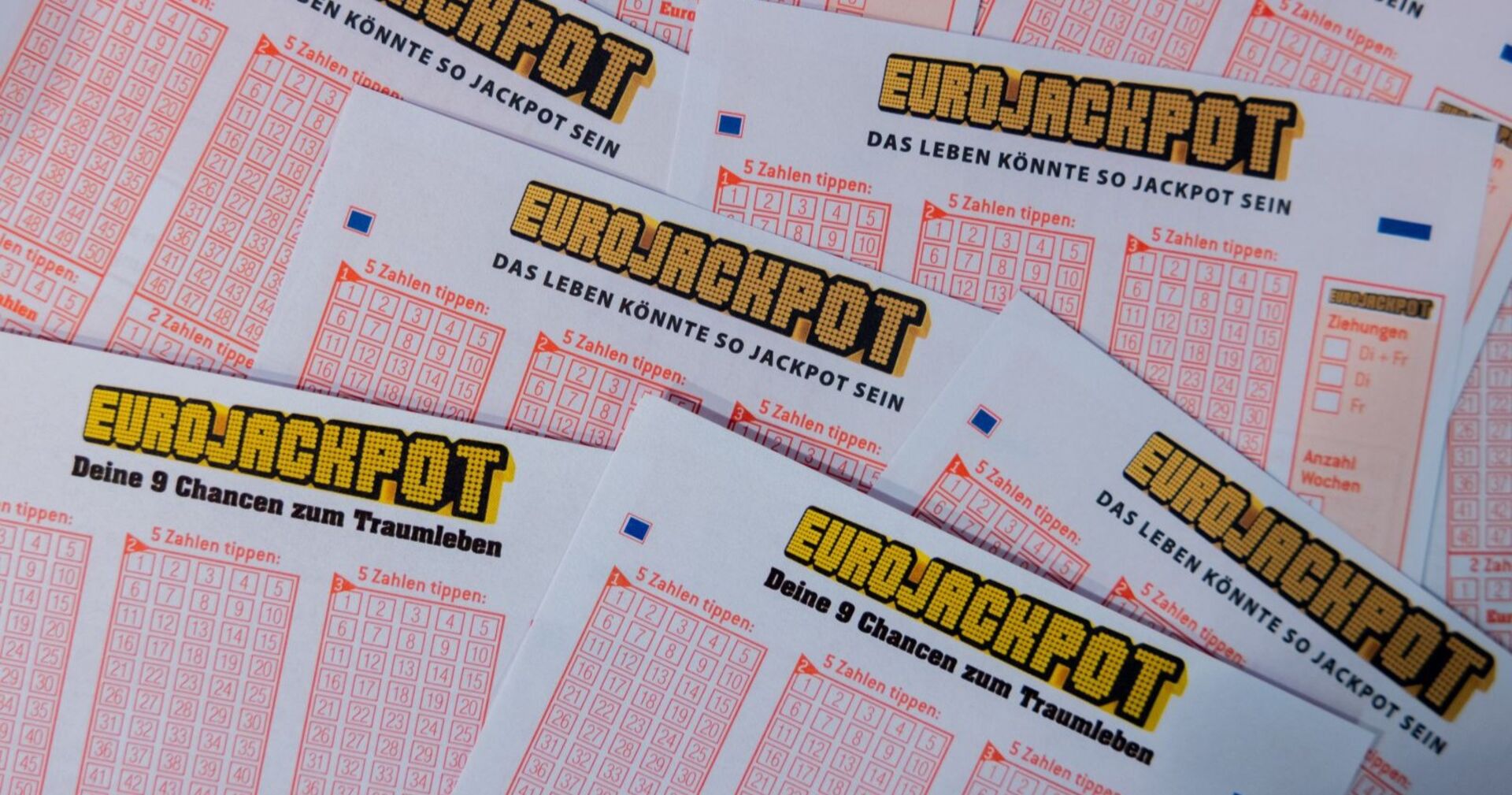 Eurojackpot-Spielscheine mit Zahlenfeldern und Logo der Lotterie, Symbolbild für den Lottogewinn.