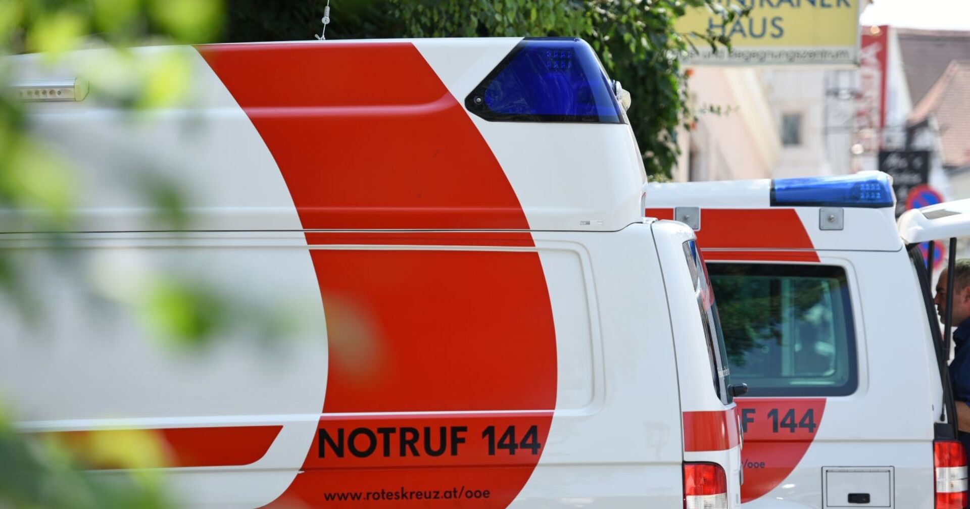 In der Reihe stehende Rettungswägen des Roten Kreuz auf einem Parkplatz