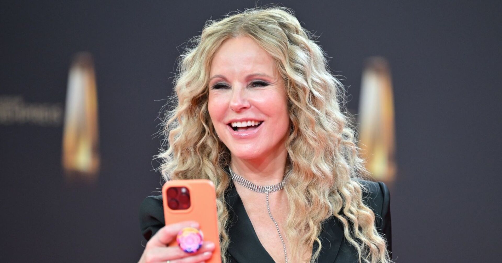 Katja Burkard mit Handy und Lachen