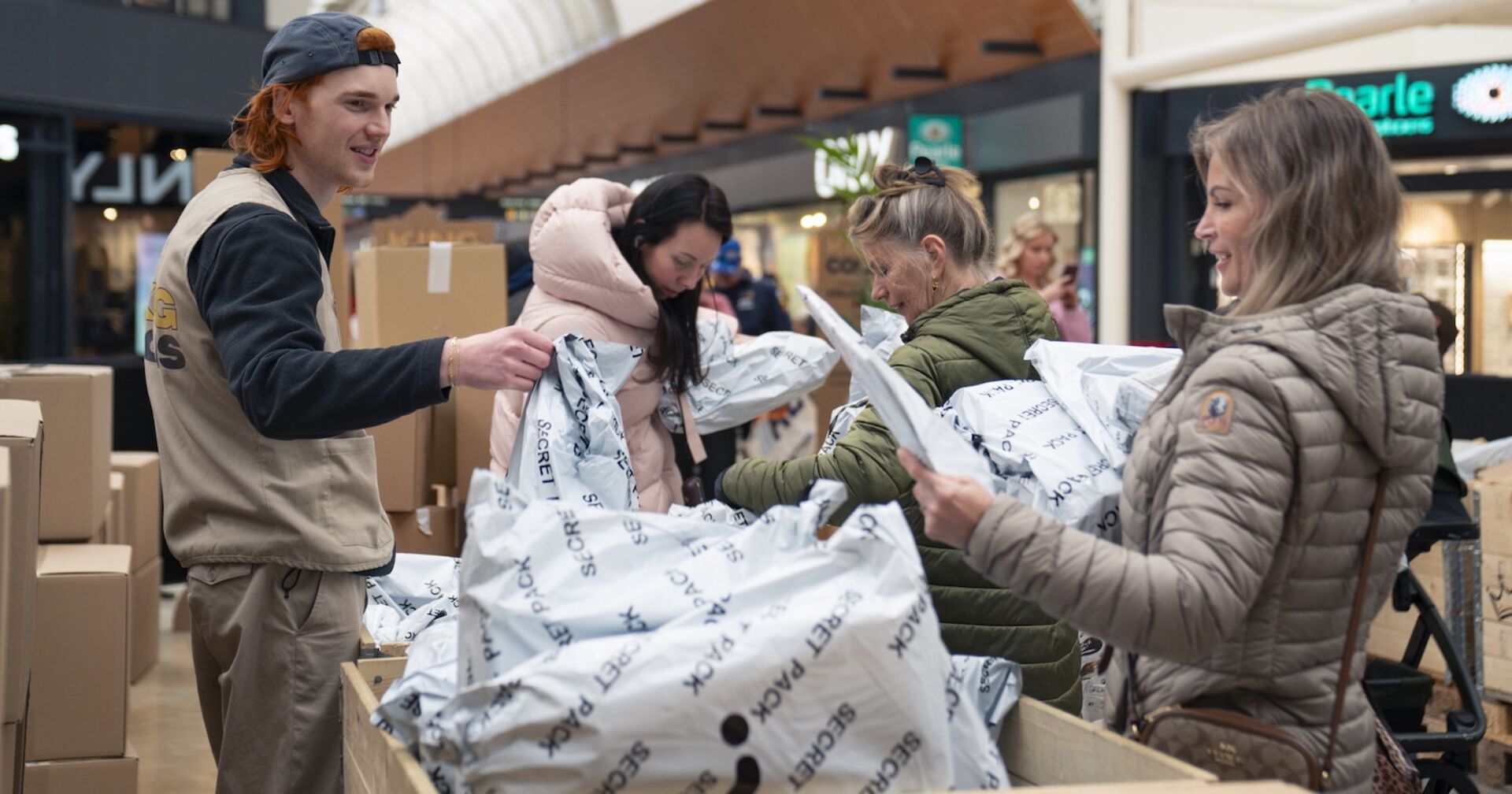 Drei Frauen suchen am Wühltisch nach Überraschungspaketen