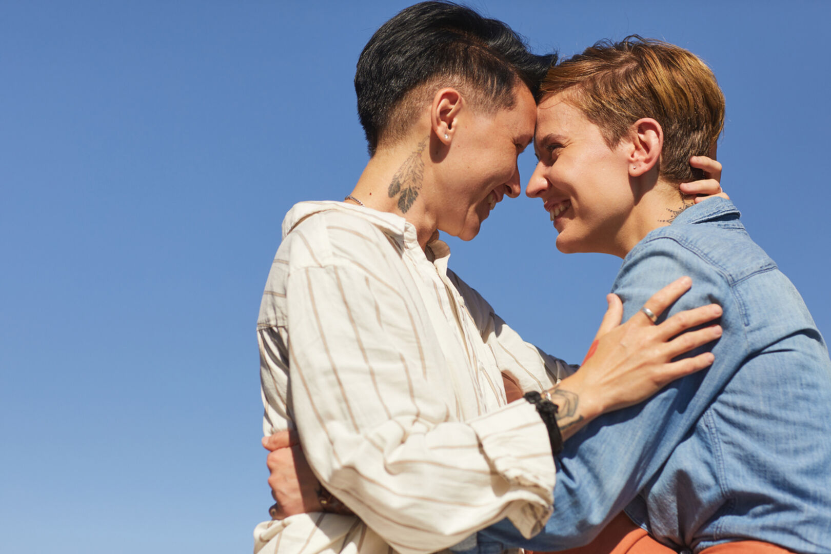 Zwei Frauen pressen die Stirn aneinander und lachen