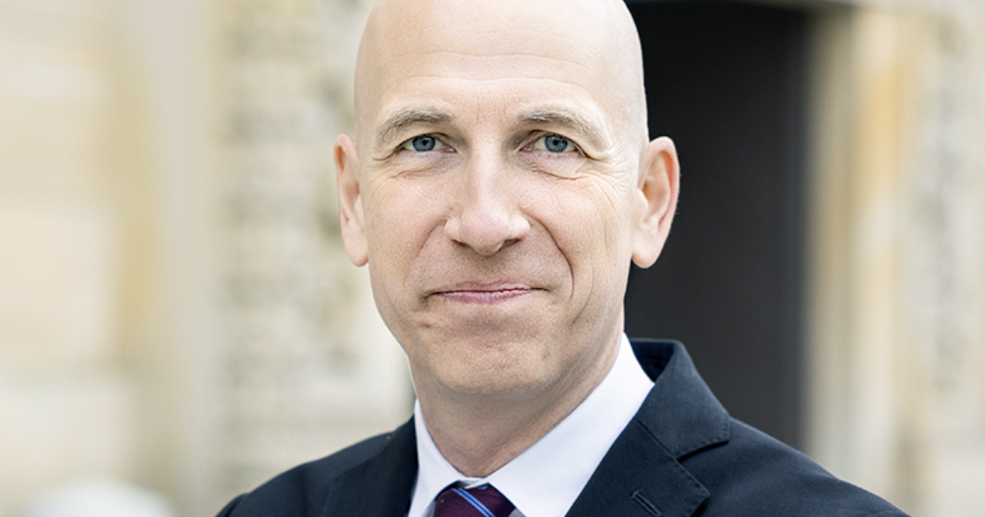 Martin Kocher im Anzug vor dem Haupteingang der Oesterreichischen Nationalbank