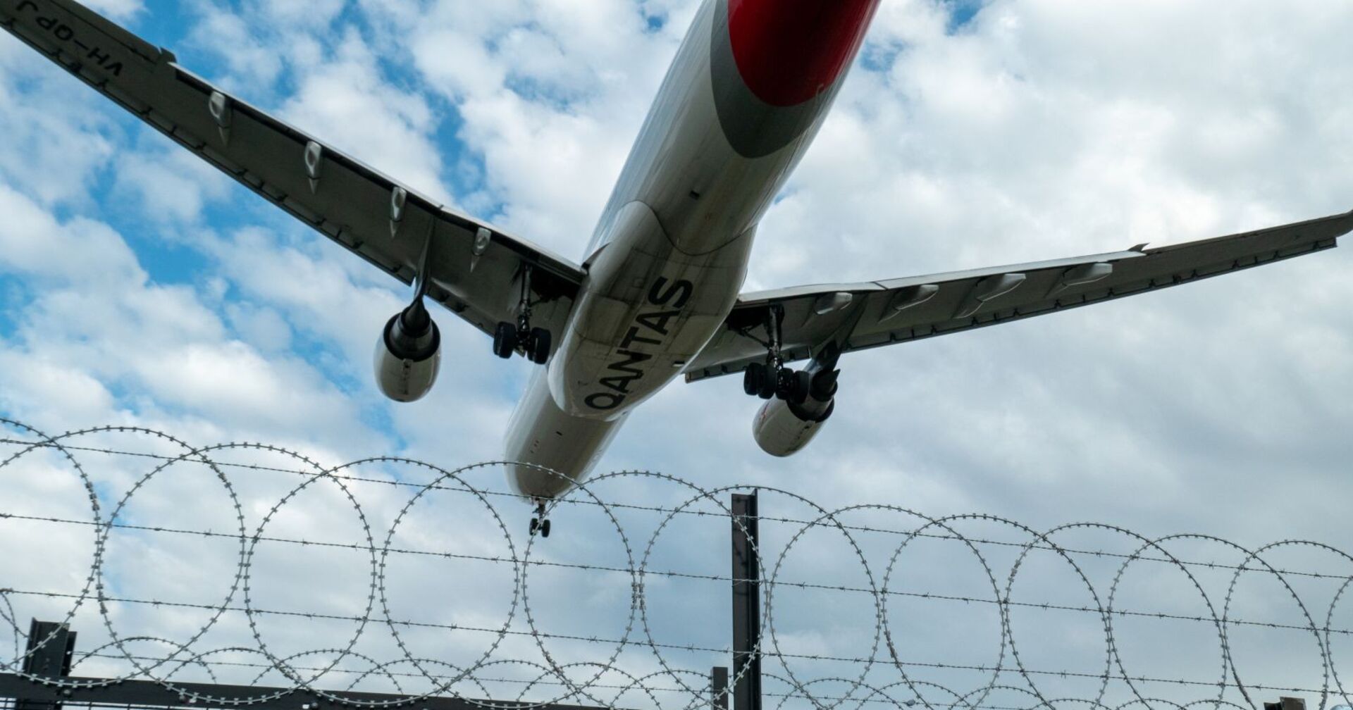 Flugzeug, welches über einem militärischen Sicherheitszaun abhebt