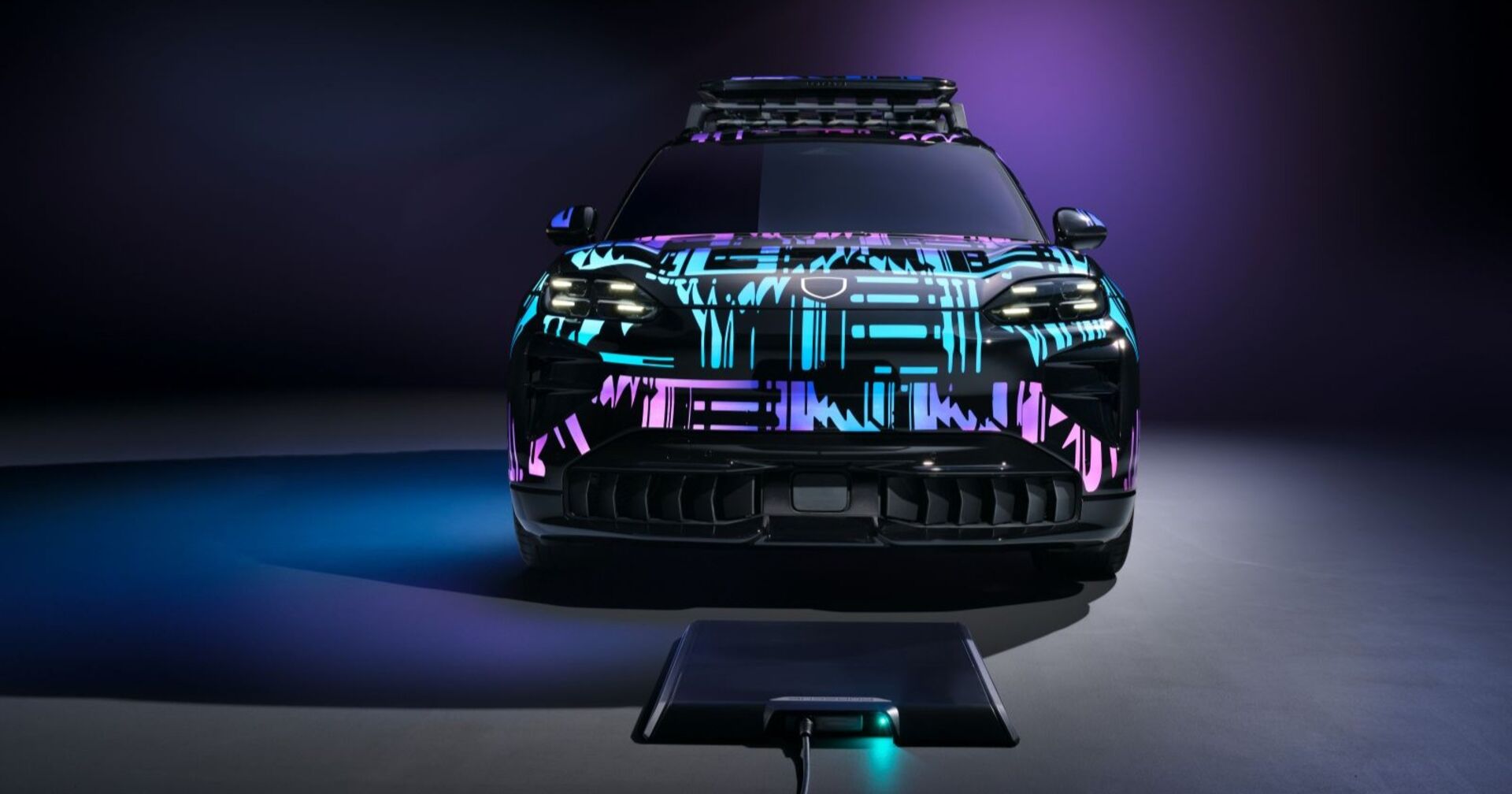 Ein in den Farben blau und rosa bemalter Porsche Cayenne steht über Bodenladeplatte, die zum laden genutzt wird.