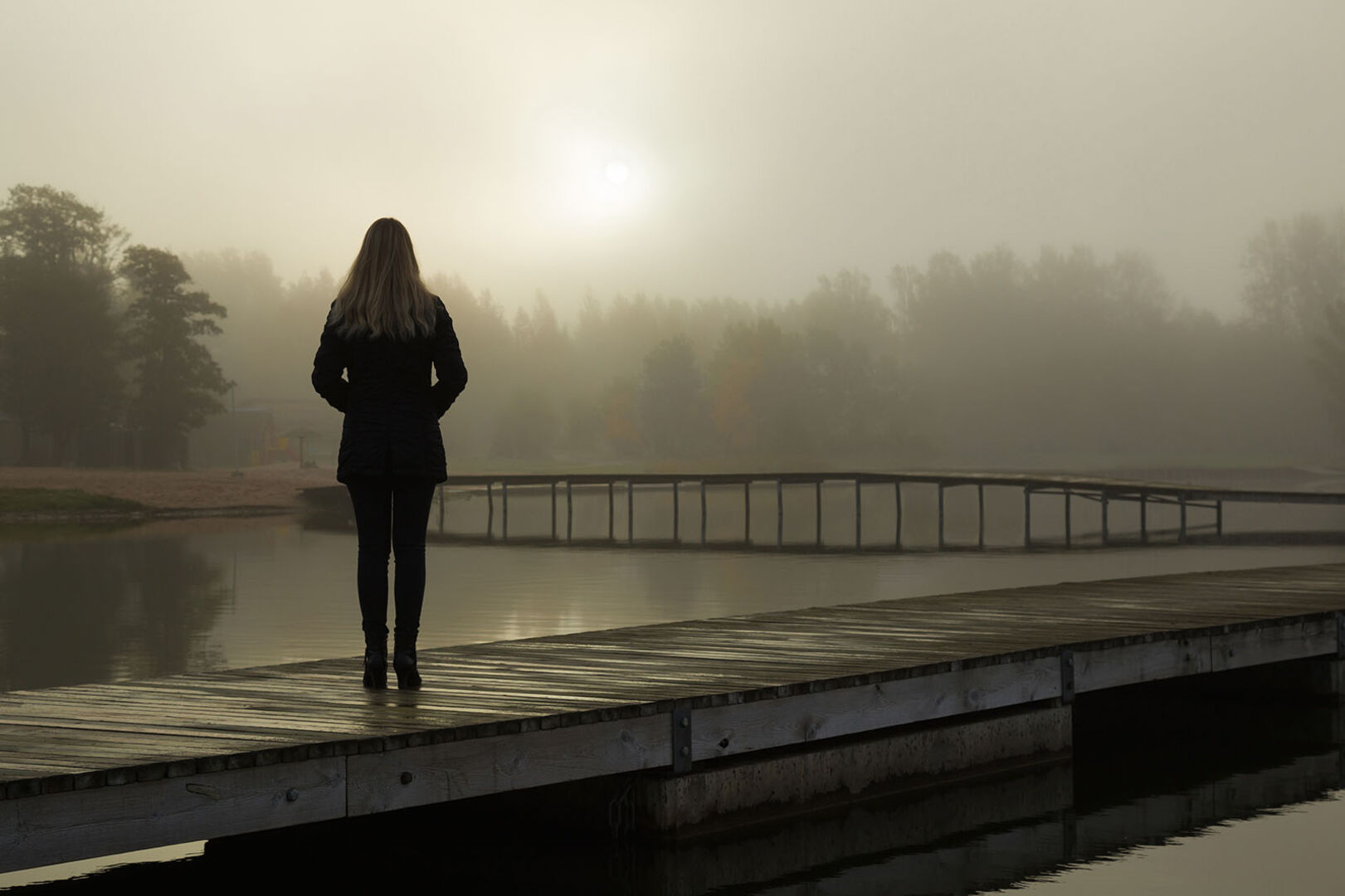Frau steht auf einem Steg | Credit: iStock.com/FotoDuets