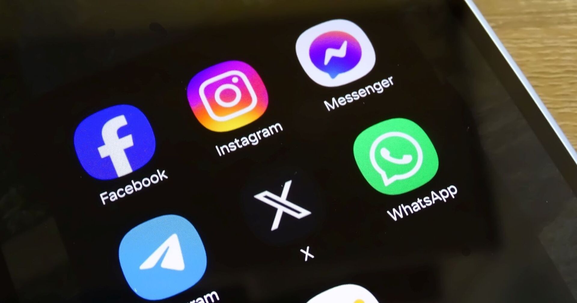Leuchtender Homescreen eines Smartphones auf dem verschiedene Social-Media-apps, unter anderem WhatsApp installiert sind
