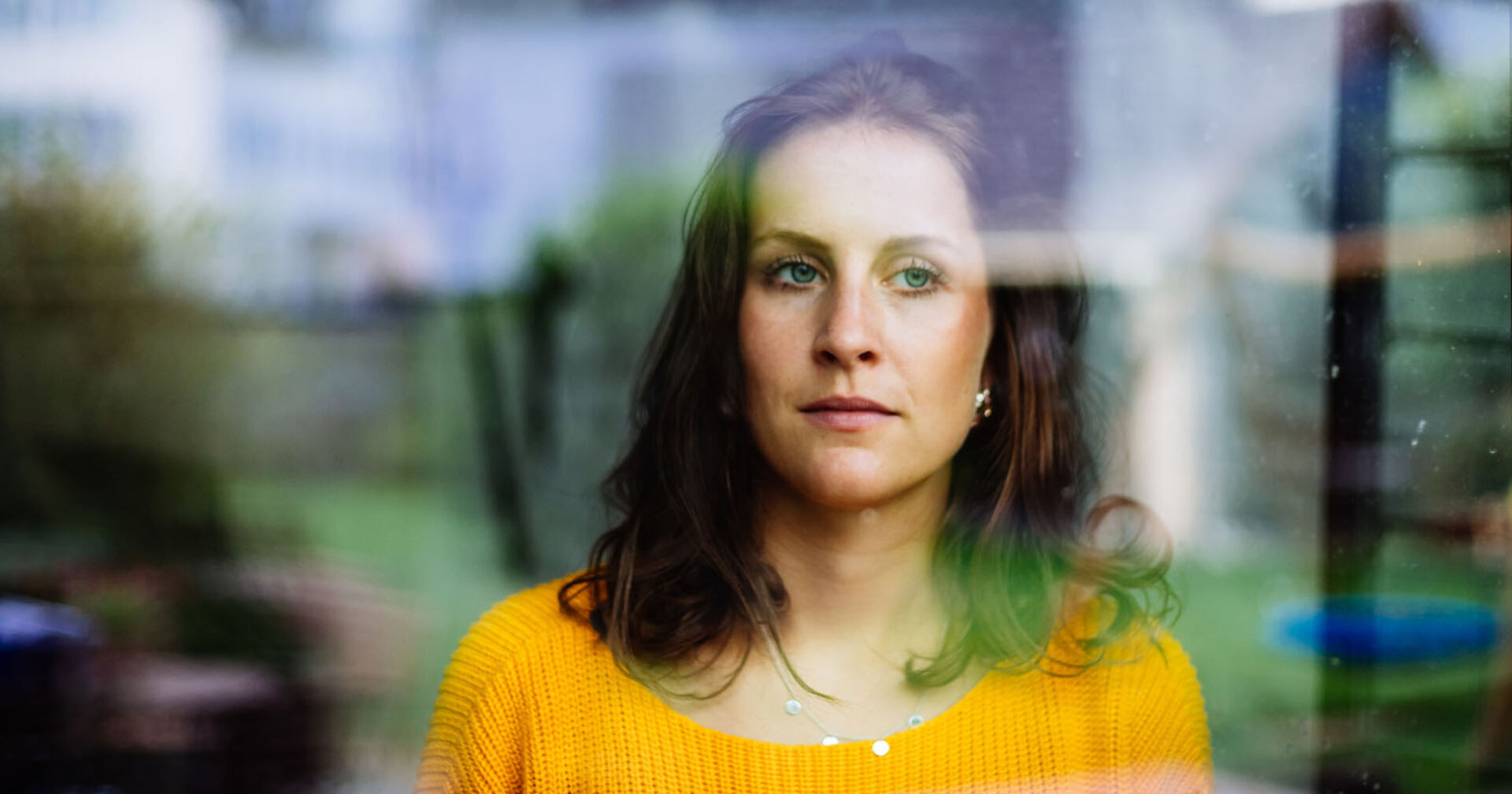 Frau schaut nachdenklich aus dem Fenster | Credit: iStock.com/Matthias Lindner