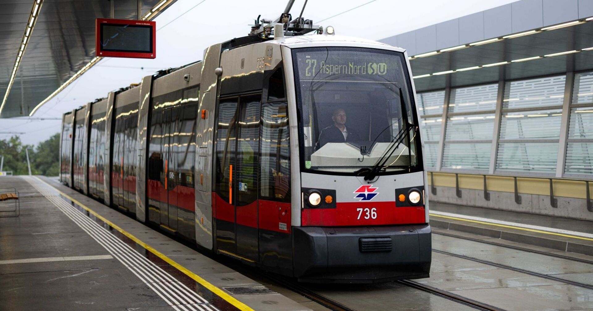 Premierenfahrt der Straßenbahnlinie 27 mit beschriftetem ULF-Zug der Firma Siemens auf der neu errichteten Statrion &quot;Aspern Nord&quot;