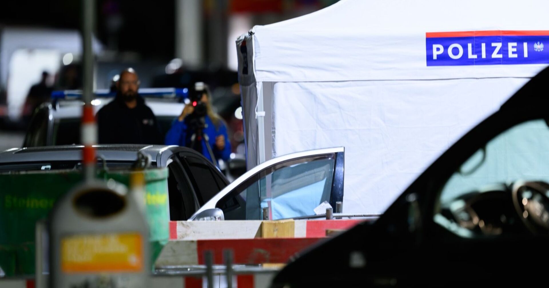 Polizei-Sichtschutzzelt und Fahrzeug mit offener Tür am Tatort in Wien-Leopoldstadt, wo der mutmaßliche Täter tot aufgefunden wurde.
