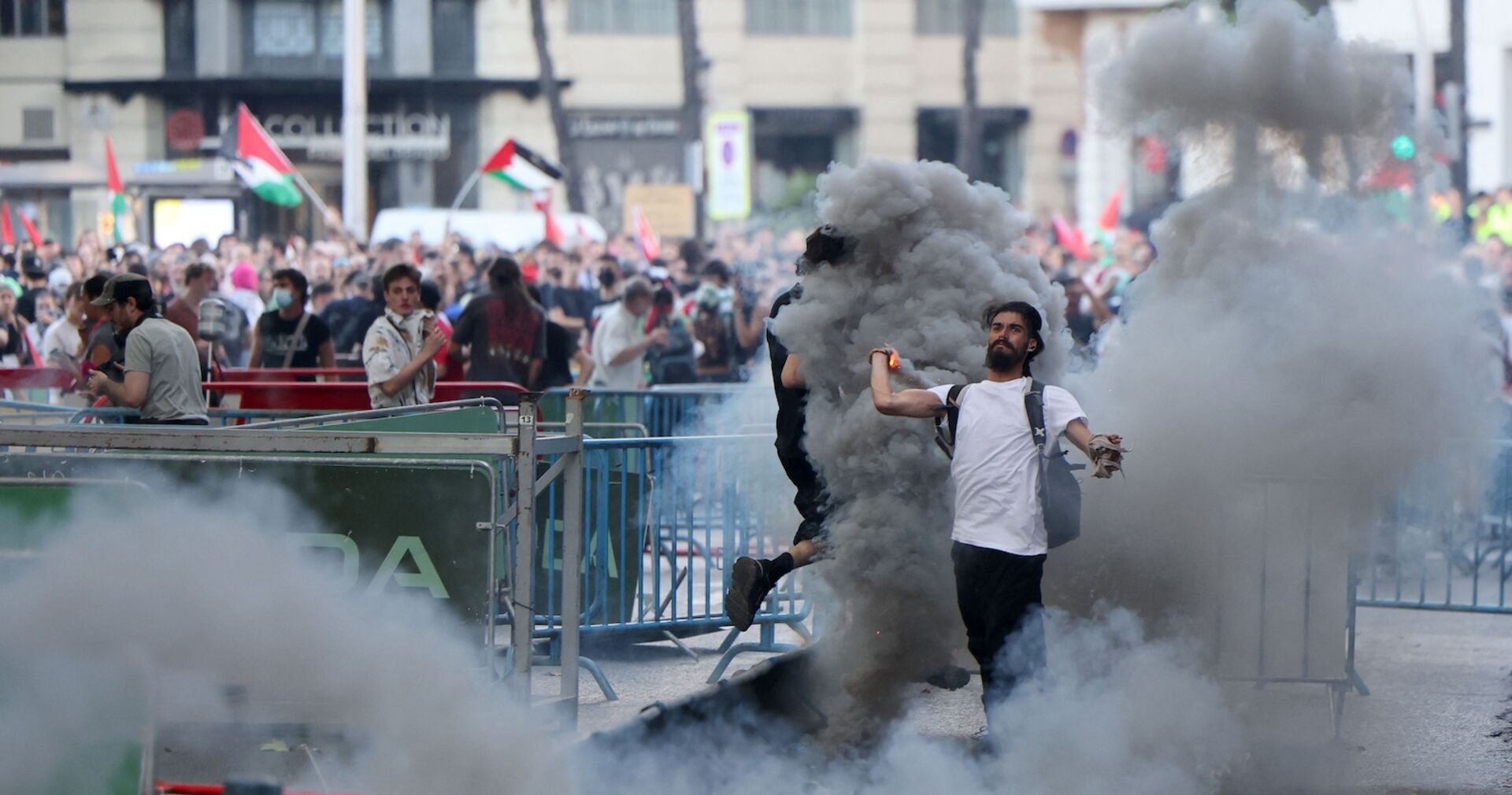 Ein Demonstrant wirft eine Rauchfackel, nachdem pro-palästinensische Protestierende während der 21. und letzten Etappe der Vuelta die Strecke blockierten.