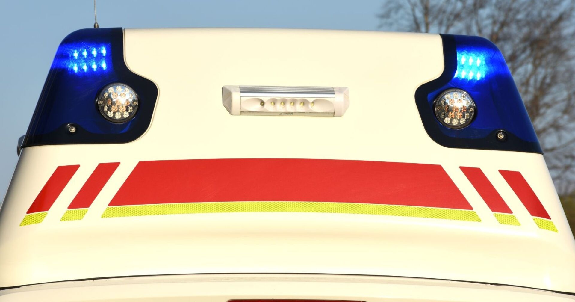 Heck eines Rettungswagens mit eingeschaltetem Blaulicht, Symbolbild für einen tragischen Notfalleinsatz in Wien.