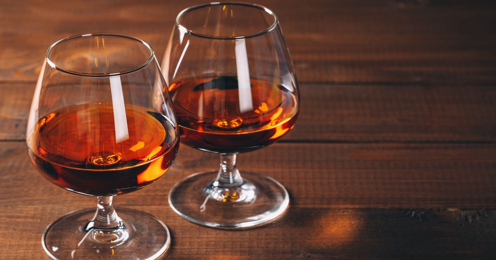 Zwei Cognac-Gläser auf einem Holztisch