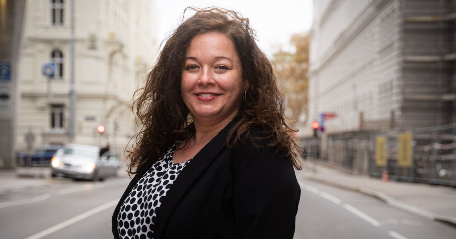 Frau mit langen, dunklen, lockigen Haaren auf der Straße