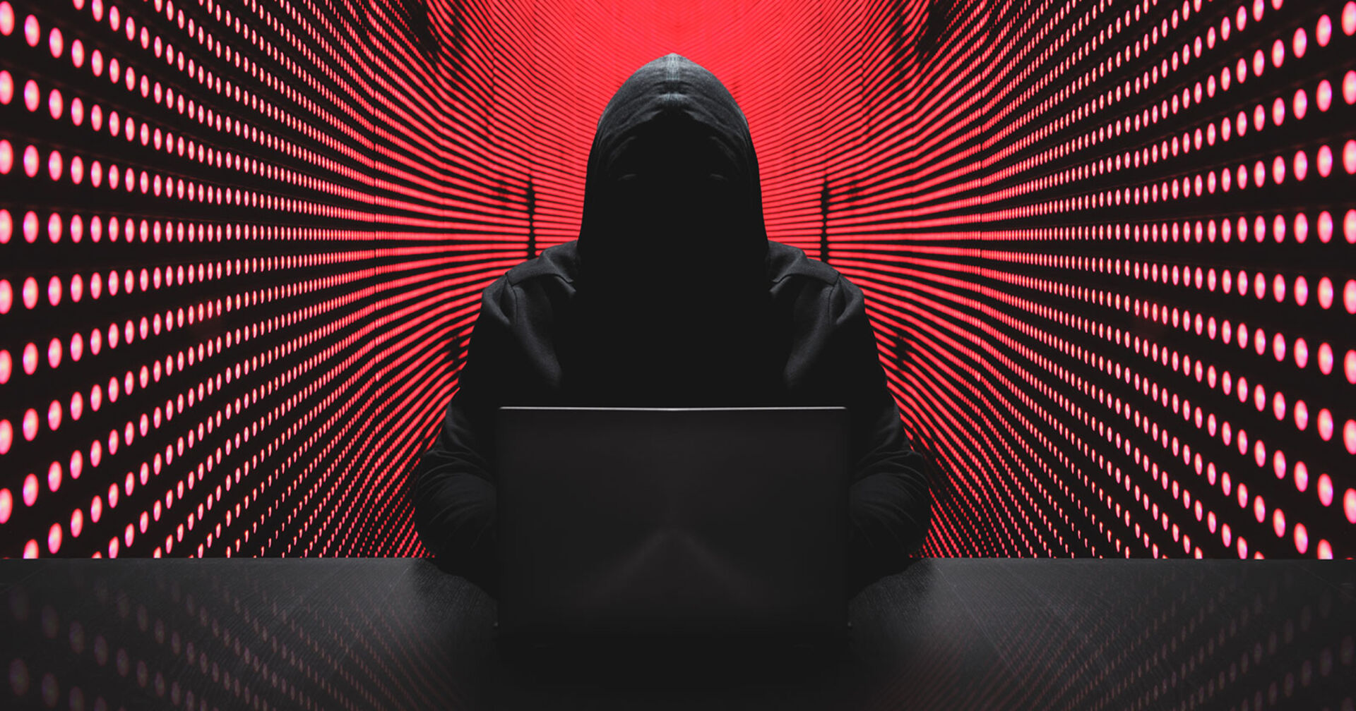 Hacker mit Kapuzenjacke vor rotem Hintergrund | Credit: iStock.com/undefined undefined