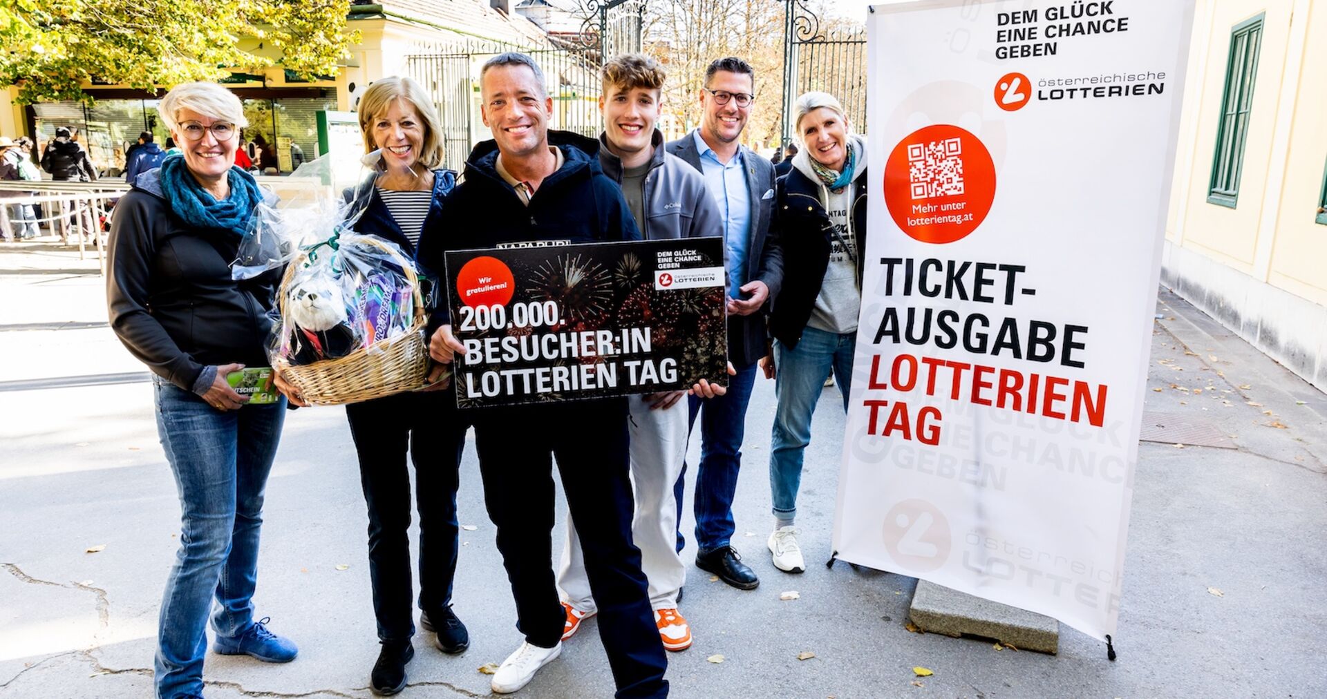 Gruppenbild mit Geschenkkorb neben Lotterientag-Augsteller
