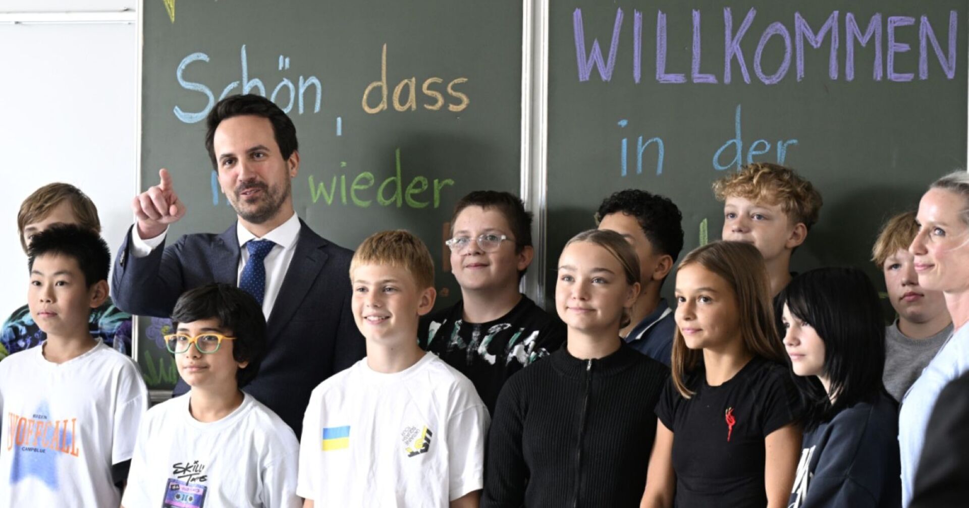 Schulklasse steht vor einer Tafel