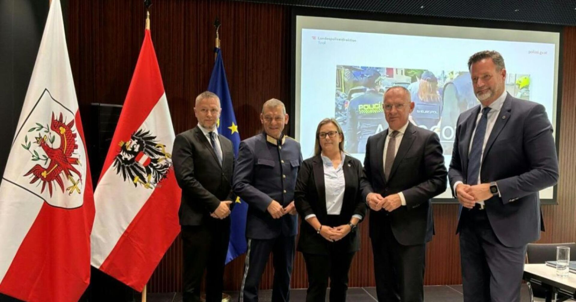 österreichische Flagge und fünf Menschen