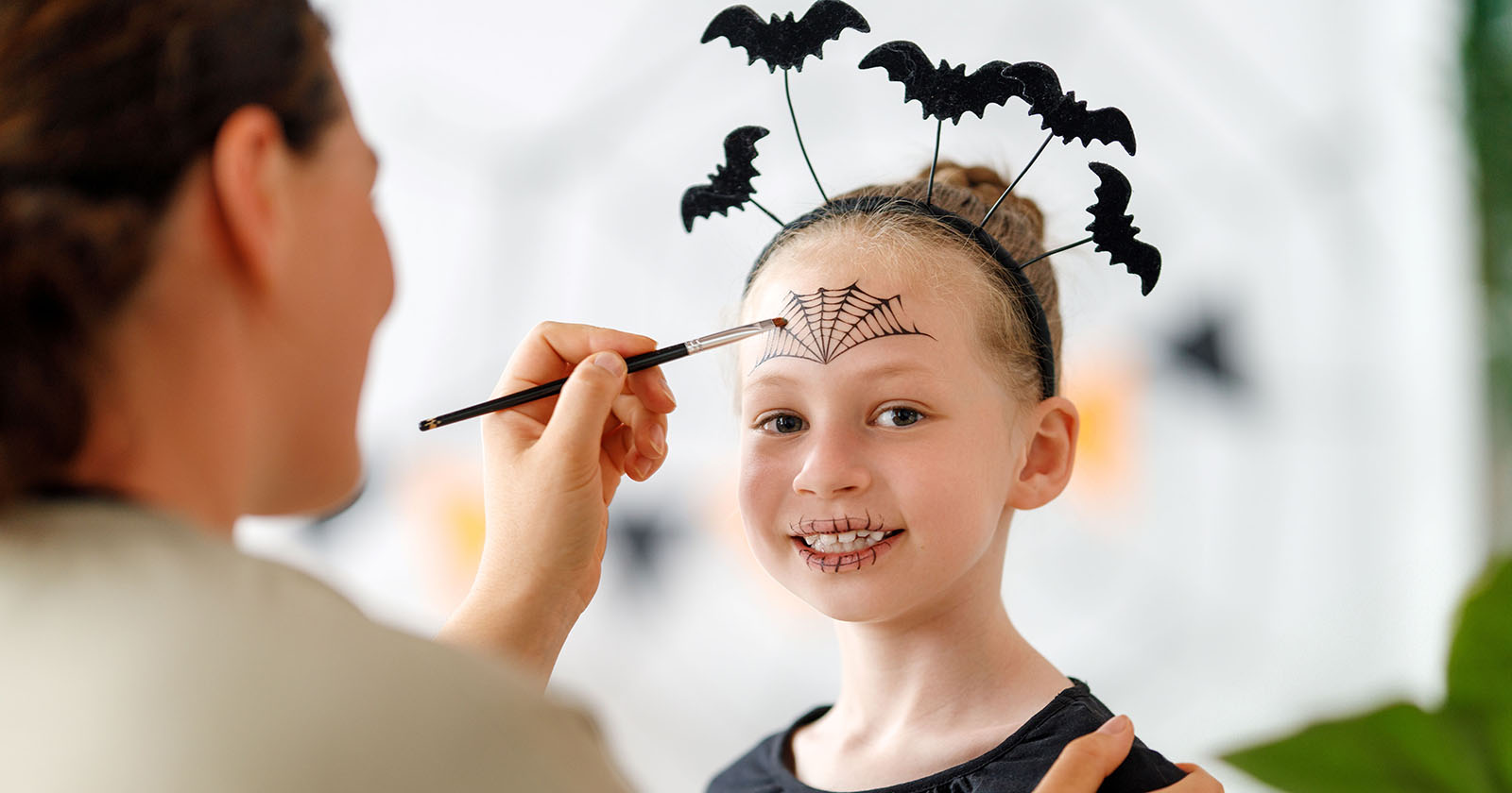 Kind wird von einer Frau gruselig geschminkt