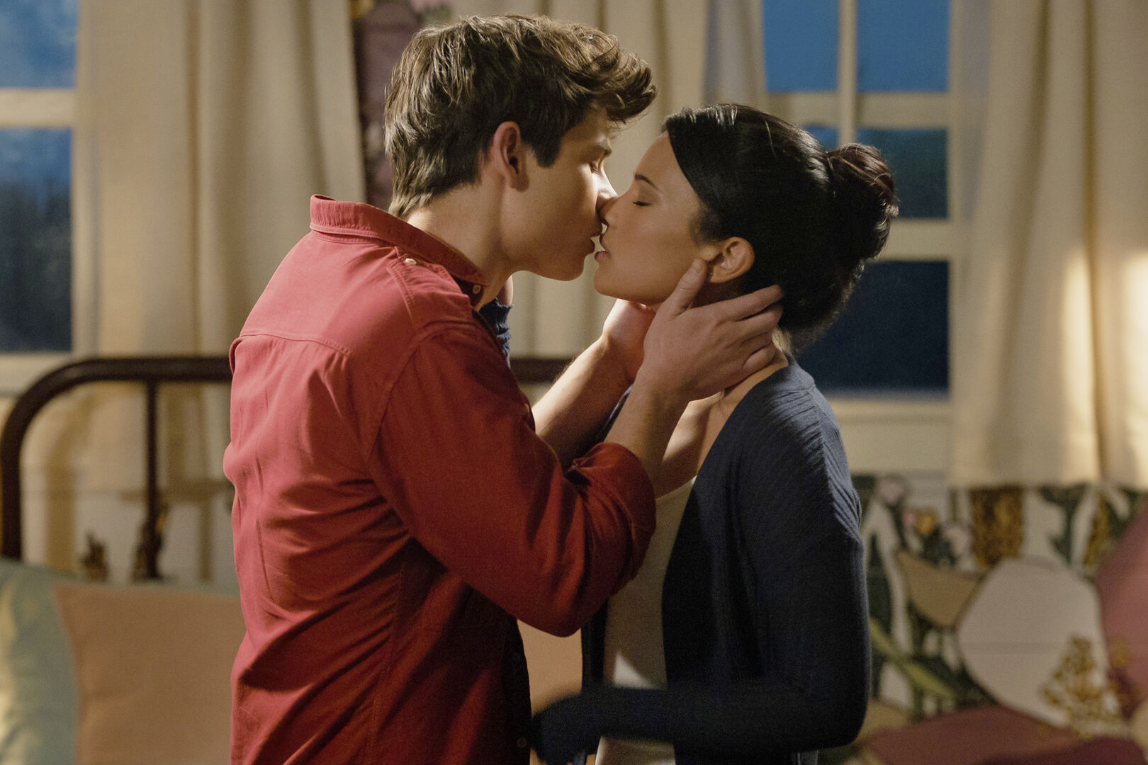 Ein junge küsst ein Mädchen, sie befinden sich in einem Zimmer