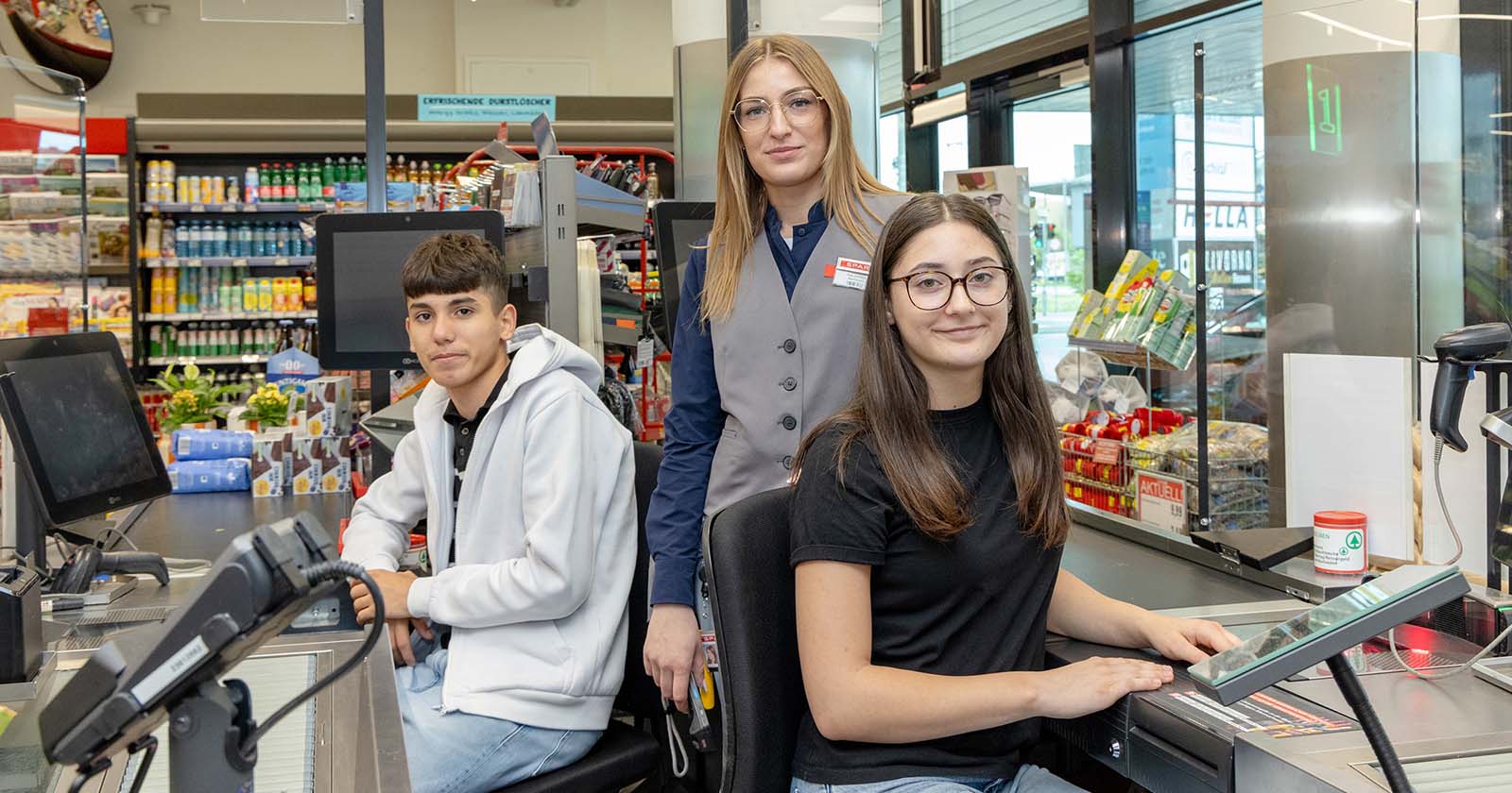 Drei Jugendliche an einer Supermarkt-Kassa