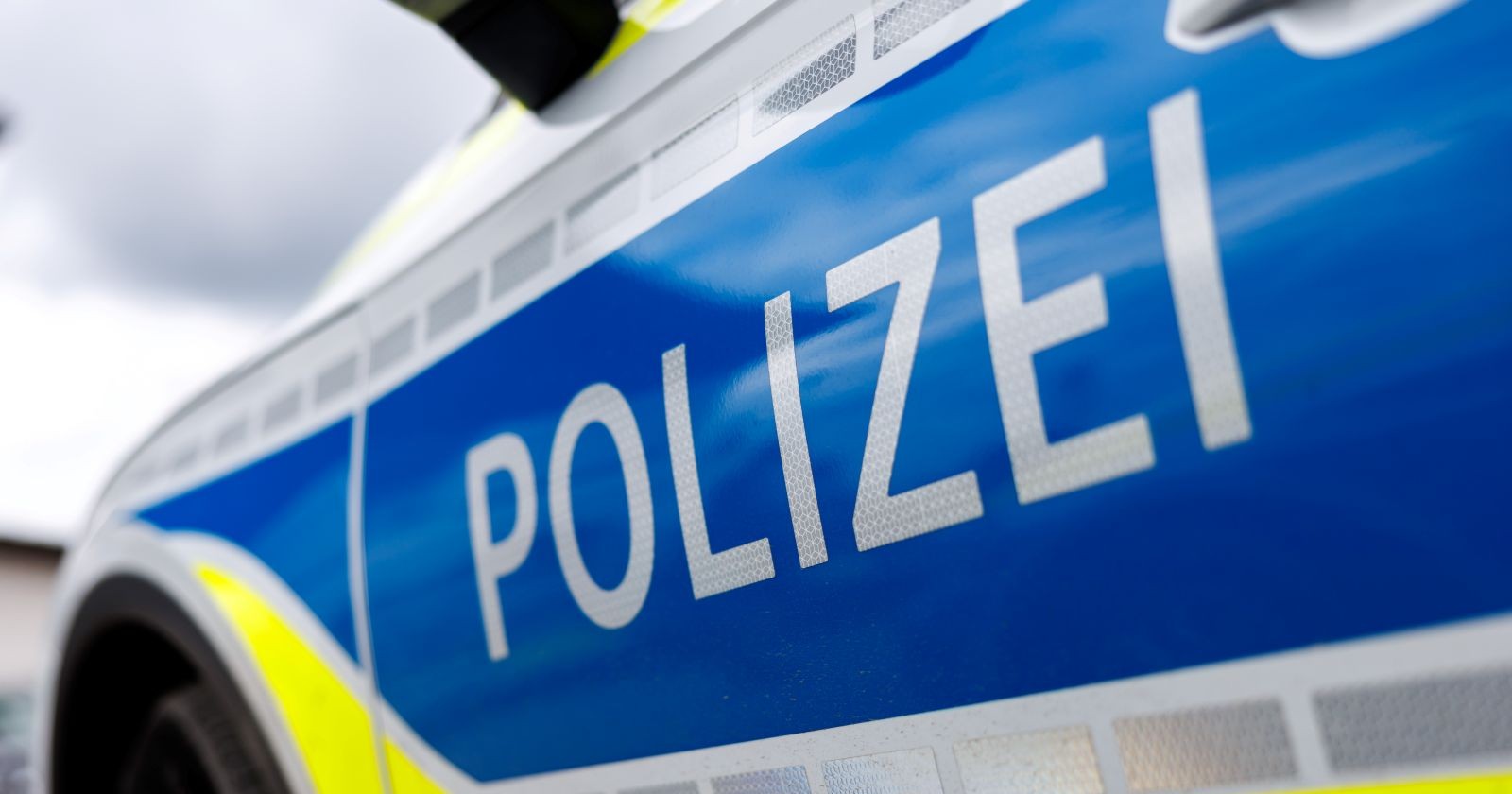 Nahaufnahme eines Polizeiautos mit der Aufschrift „Polizei“ – Symbolbild für den Großeinsatz in Essen nach einem Messerangriff an einer Schule.