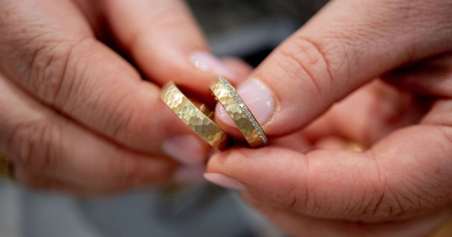 Ein Mann hält zwei Eheringe in der Hand.