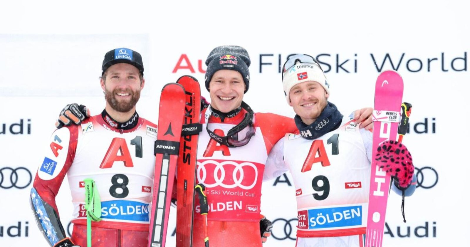 Siegerfoto mit Schwarz, Odermatt und McGrath; die drei Männer stehen dicht beieinander, halten ihre Ski und lächeln in die Kamera.