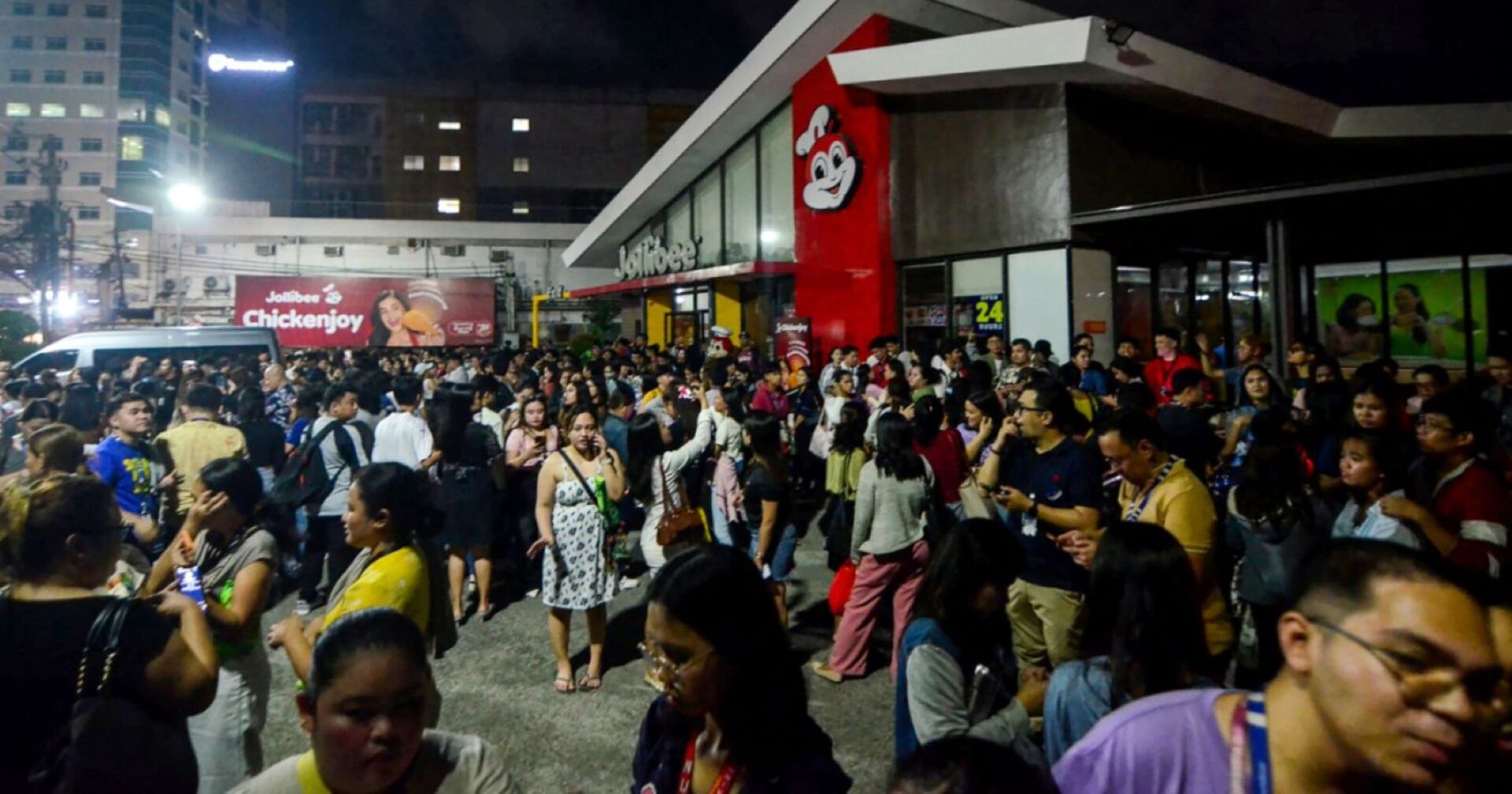 Versammelte Menschen auf den Philippinen auf einem Parkplatz vor einem Lokal der Fast-Food-Kette &quot;Jollybee&quot; nach dem Erdbeben