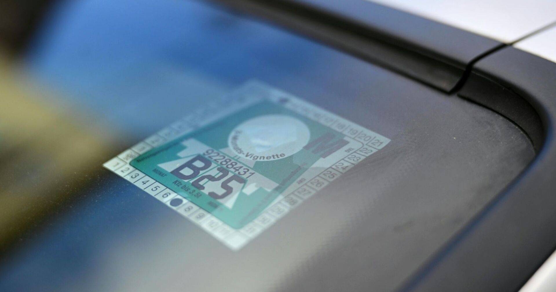 Nahaufnahme einer österreichischen Klebevignette auf der Windschutzscheibe eines Autos.